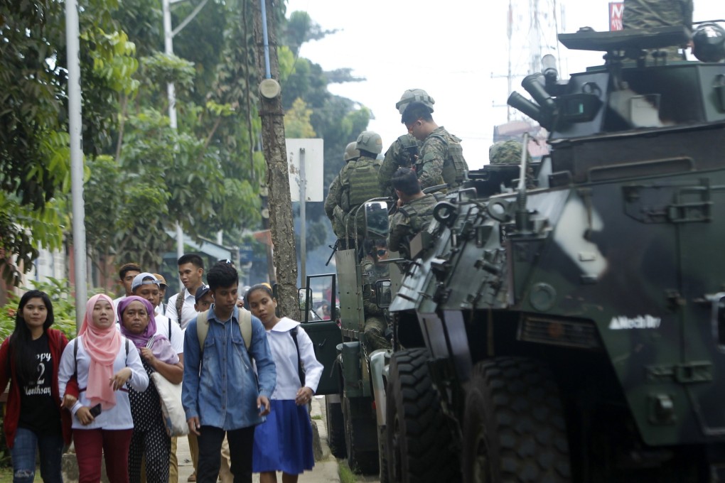 Philippine government troops on armoured vehicles conduct a patrol in Jolo town a day after Monday’s referendum was held. Photo: EPA