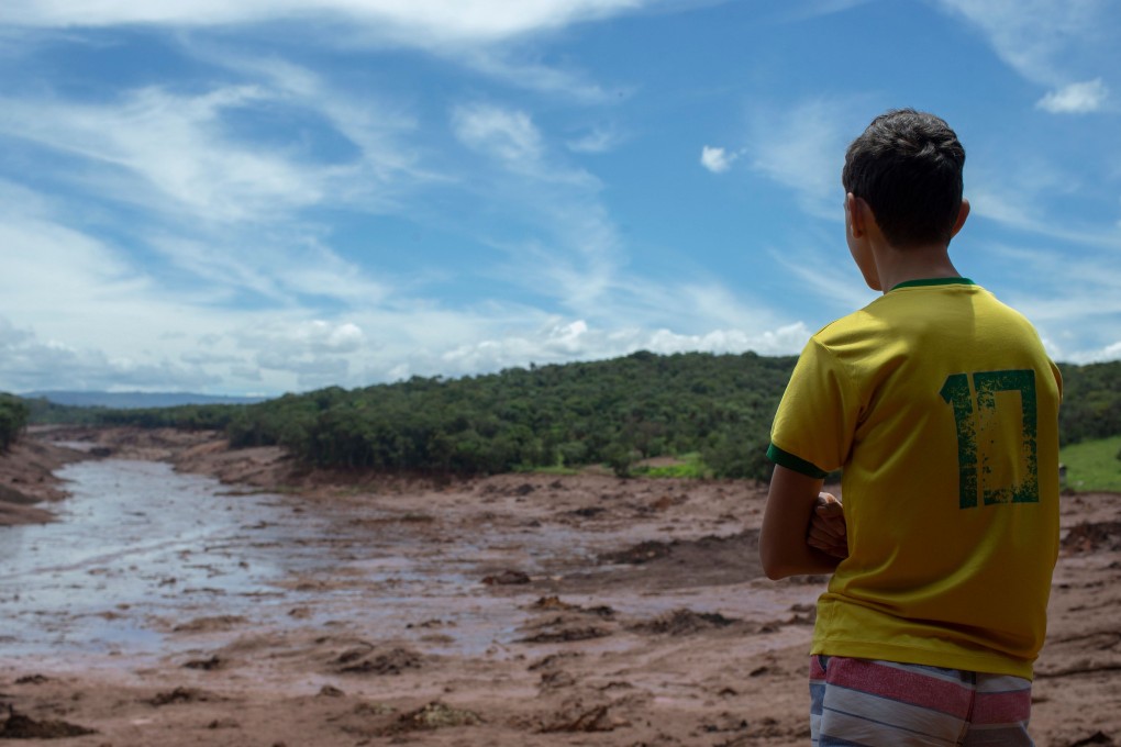 A boy looks at an area in the community of Casa Grande affected by a sludge after the collapse, two days ago, of a dam at an iron-ore mine belonging to Brazil's giant mining company Vale near the town of Brumadinho. Photo: AFP