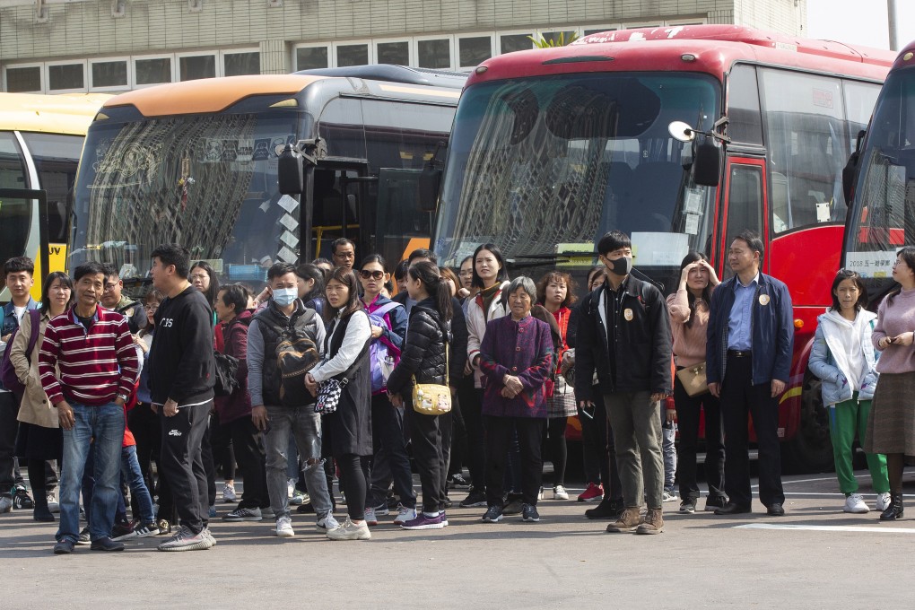 Mainland tourists who arrived to visit To Kwa Wan and Hung Hom on January 26 watch as residents of those areas march to protest the overcrowding. Photo: EPA