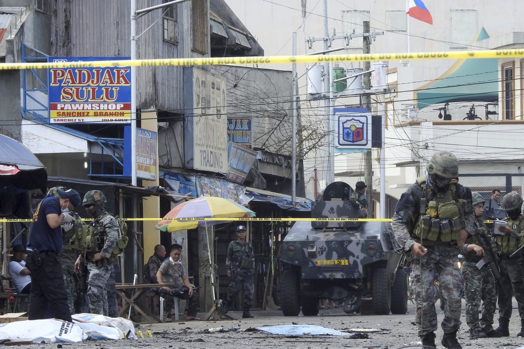 Police investigators and soldiers attend the scene after two bombs exploded outside a Roman Catholic cathedral in Jolo, the capital of Sulu province in southern Philippines. Photo: AP Photo