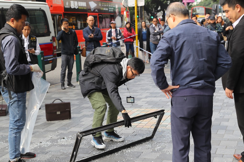 Police officers examine a fallen window outside The Mira Hong Kong hotel in Tsim Sha Tsui after a falling window struck and killed a woman on January 21. Photo: Edmond So