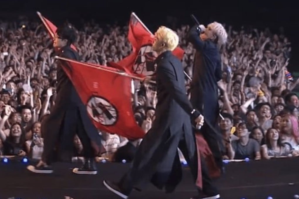 An image from a 2017 concert where BTS members wore uniforms and waved flags that critics said recalled Nazi symbols.
