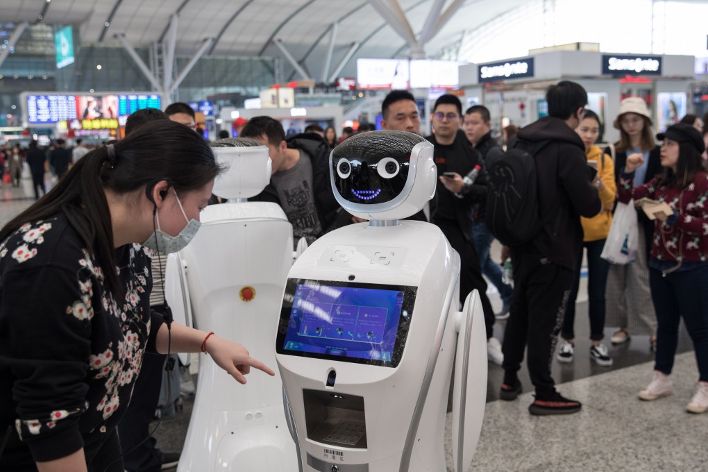 A woman approaches an information robot at the Shenzhen North railway station. Photo: EPA