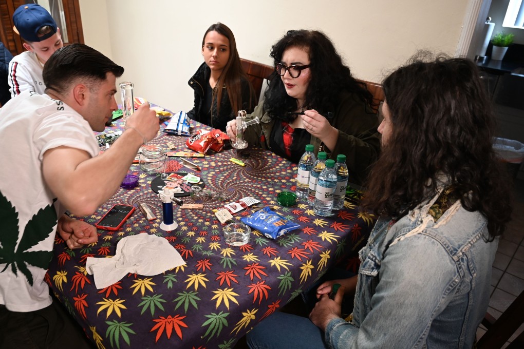 Cannabis tour guide Ryan Lance (left) explains to tour members how to prepare a dab rig [used to smoke marijuana concentrate or oil] as his tour group makes a stop. Photo: Robyn Beck