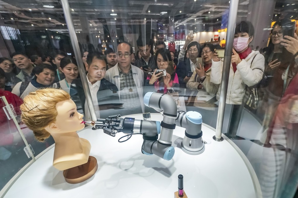 Visitors watch a robot arm putting make-up on a mannequin at the first China International Import Expo in Shanghai on November 9. Weakening import demand in China could spell trouble for world trade. Photo: Xinhua