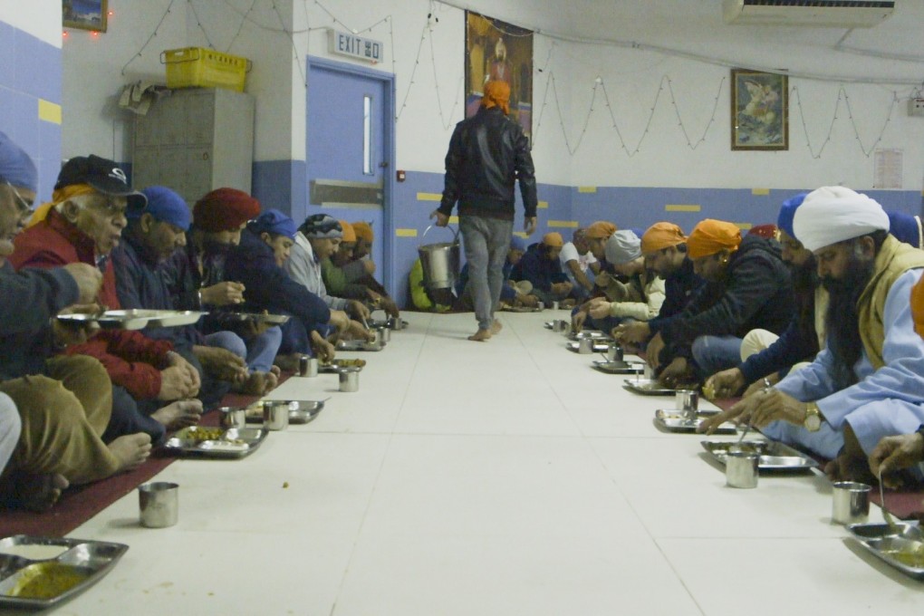 Community eating at the Sikh temple Khalsa Diwan in Wan Chai, Hong Kong. Photo: Mantai Chow