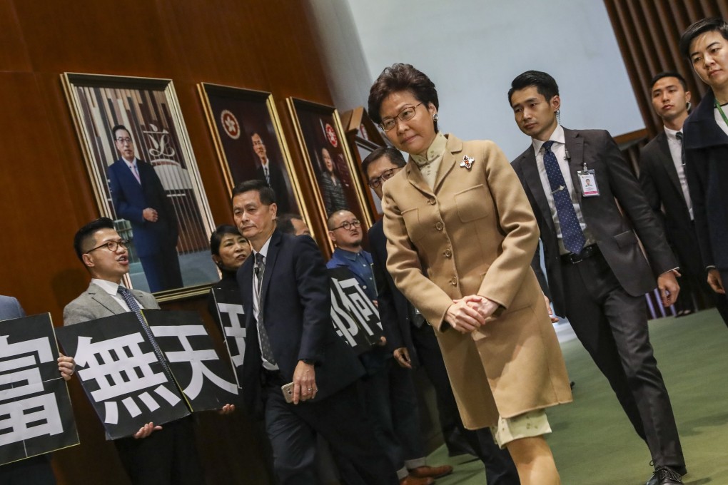 Pan-democrat lawmakers stage a protest while Hong Kong Chief Executive Carrie Lam walks into the Legislative Council before a Q&A session in Tamar, Admiralty, on January 10. Photo: K. Y. Cheng