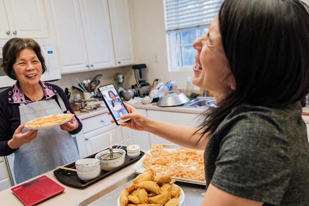 Lisa Lin recording a video of her 73-year-old mother describing the savoury fried butterfly crackers she has just cooked. Photo: Nick Otto for The Washington Post