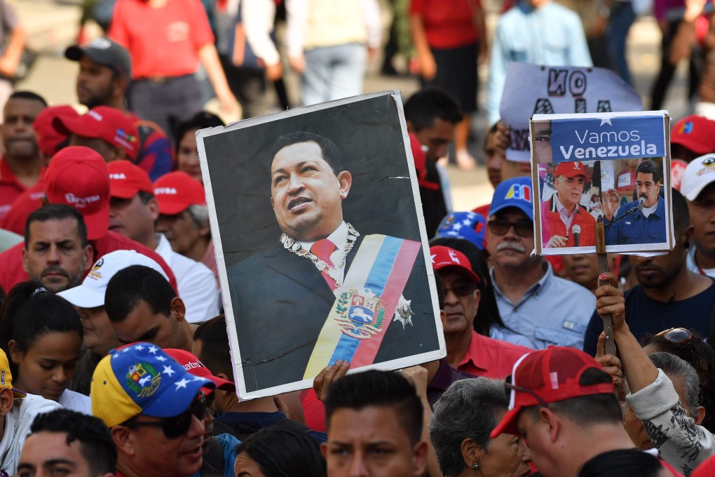 A demonstrator holds a picture of the socialist President Hugo Chavez, who died in 2013, as workers from Venezuela's state oil company, PDVSA, participate in an “anti-imperialist” march promoted by the government to support Venezuelan President Nicolas Maduro, in Caracas on Thursday. Photo: AFP