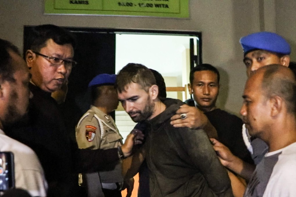 Frenchman Felix Dorfin (C) is under escort after escaping from jail in Mataram on the holiday island of Lombok on February 2, 2019, helped by a police officer who received 1,000 USD bribe from him. – A French drug suspect, who has been on the run in Indonesia for about 10 days, has been recaptured by the police. Dorfin was found in Pusuk forest in North Lombok late on February 1, police said, and was immediately taken back to the police jail in Lombok's capital Mataram. (Photo by PIKONG / AFP)