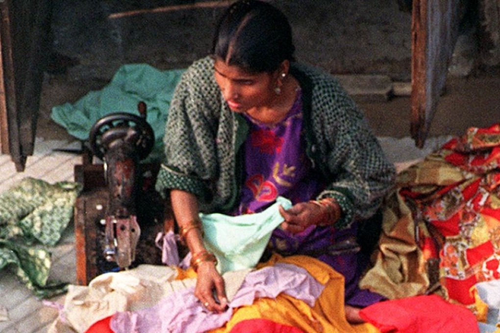 A woman sews clothes in New Delhi. File photo: AFP
