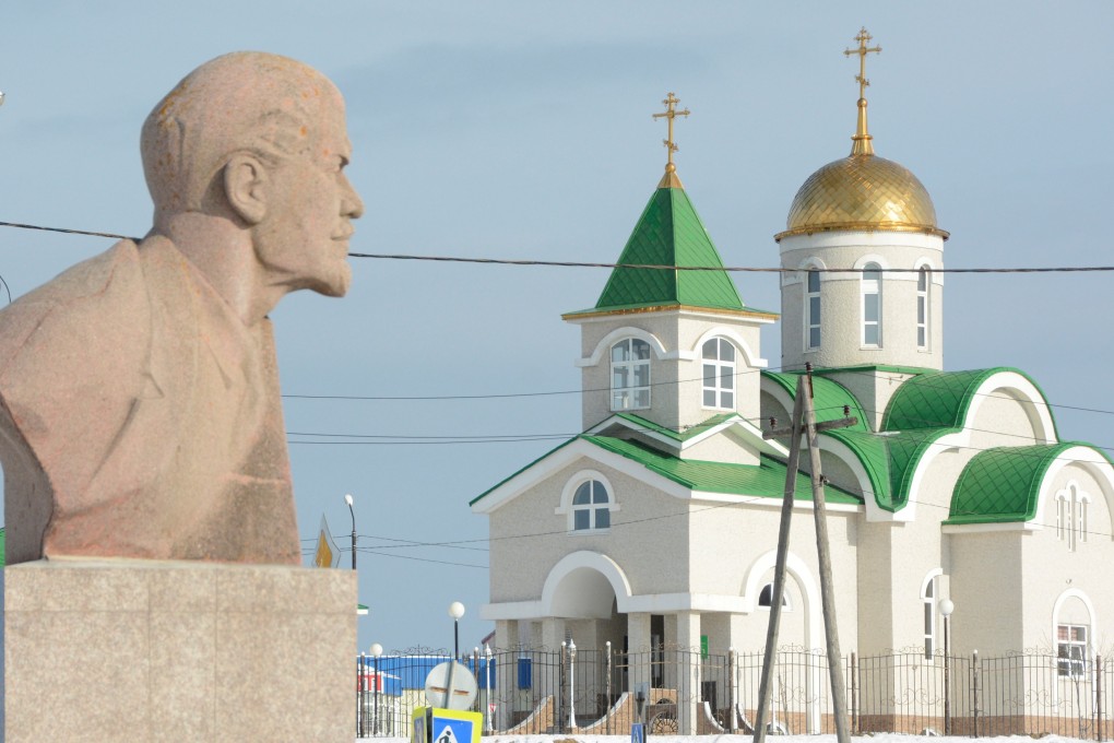 A bust of Soviet state founder Vladimir Lenin is seen in front of a Russian Orthodox church in Yuzhno-Kurilsk on the Island of Kunashir, one of four islands known as the Southern Kurils in Russia and the Northern Territories in Japan. Photo: Reuters