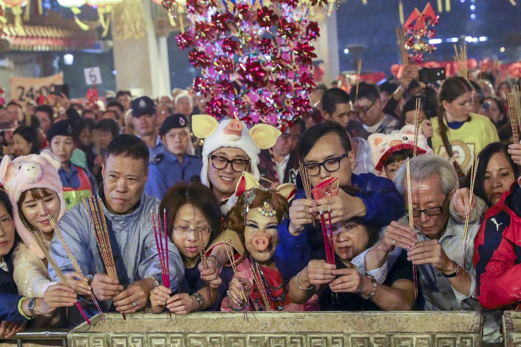 Worshippers, including former actress Lana Wong Hai-wai (centre, in pig costume) offer the first incense at Wong Tai Sin Temple on Lunar New Year's Eve. Photo: Edmond So