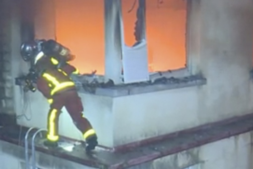 A firefighter scales the top floors of the building in flames. Photo: Paris Fire Department