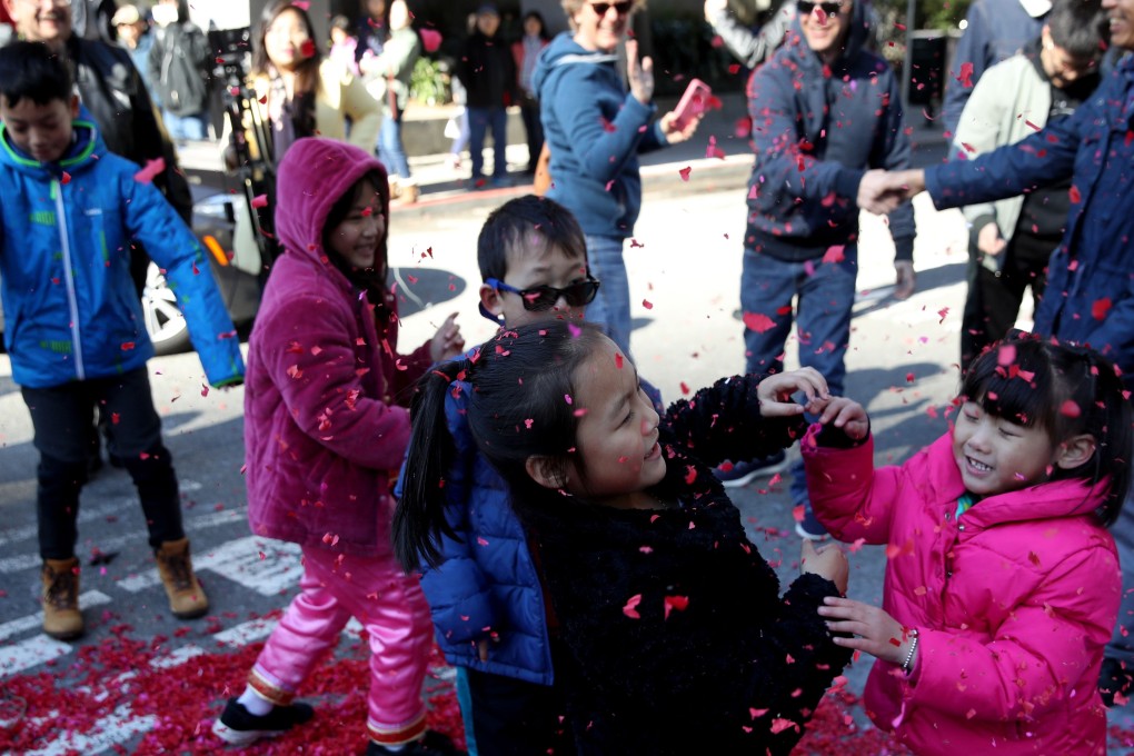 Children play with exploded firecracker wrappers while ushering in Lunar New Year, on Tuesday, in San Francisco, California. San Francisco will have a month-long celebration as part of the Year of the Pig. Photo: Getty Images/AFP