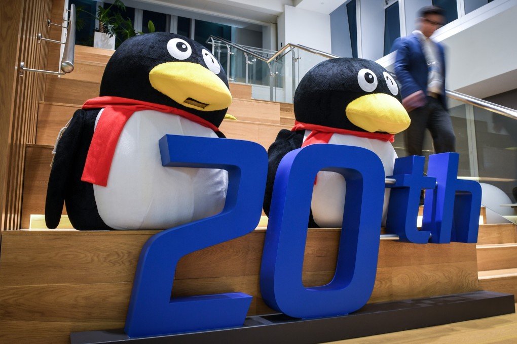 A staff walks past decorations for the 20th anniversary of the founding of Tencent Holdings at an office building of the company in Shenzhen. Photo: Xinhua