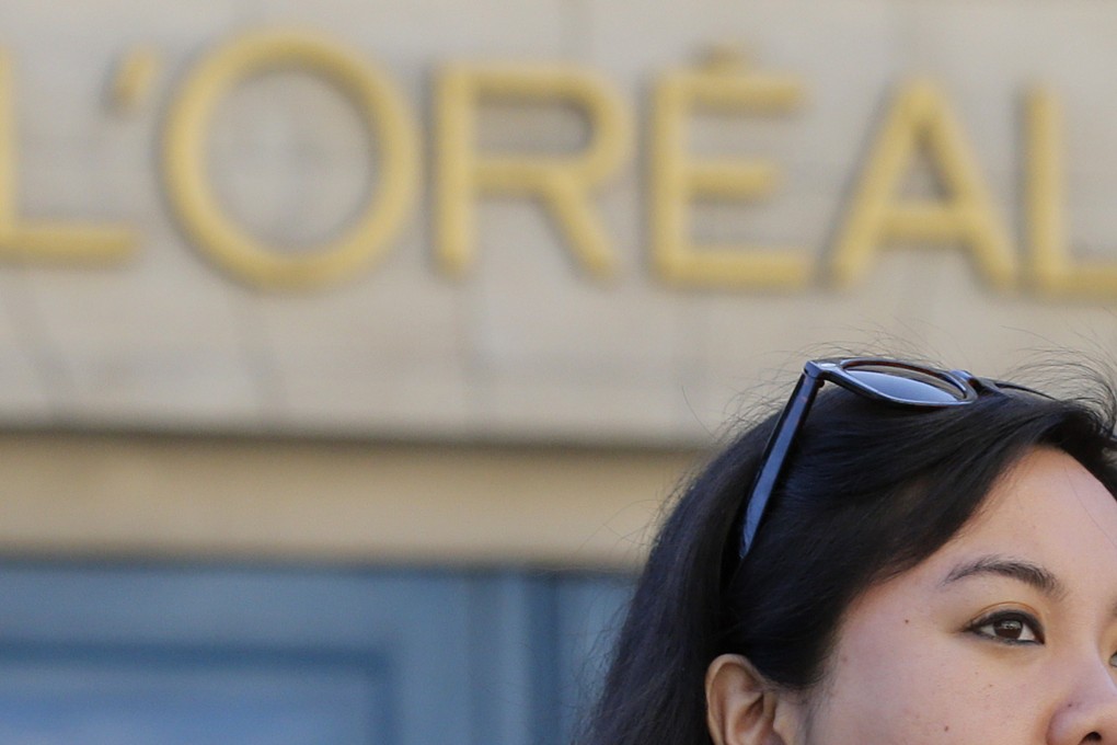 A tourist walks past the entrance of cosmetics company L’Oreal in Paris in 2013. Photo: Reuters