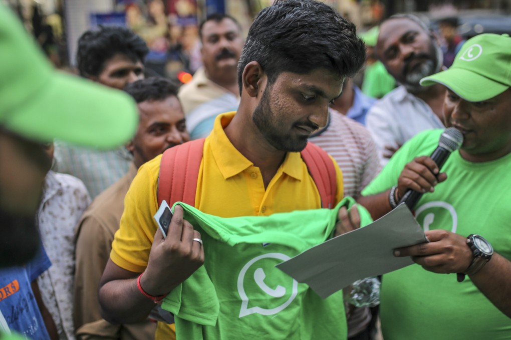 A spectator holds a branded T-shirt during a roadshow for Facebook’s WhatsApp messaging service. Photo: Bloomberg