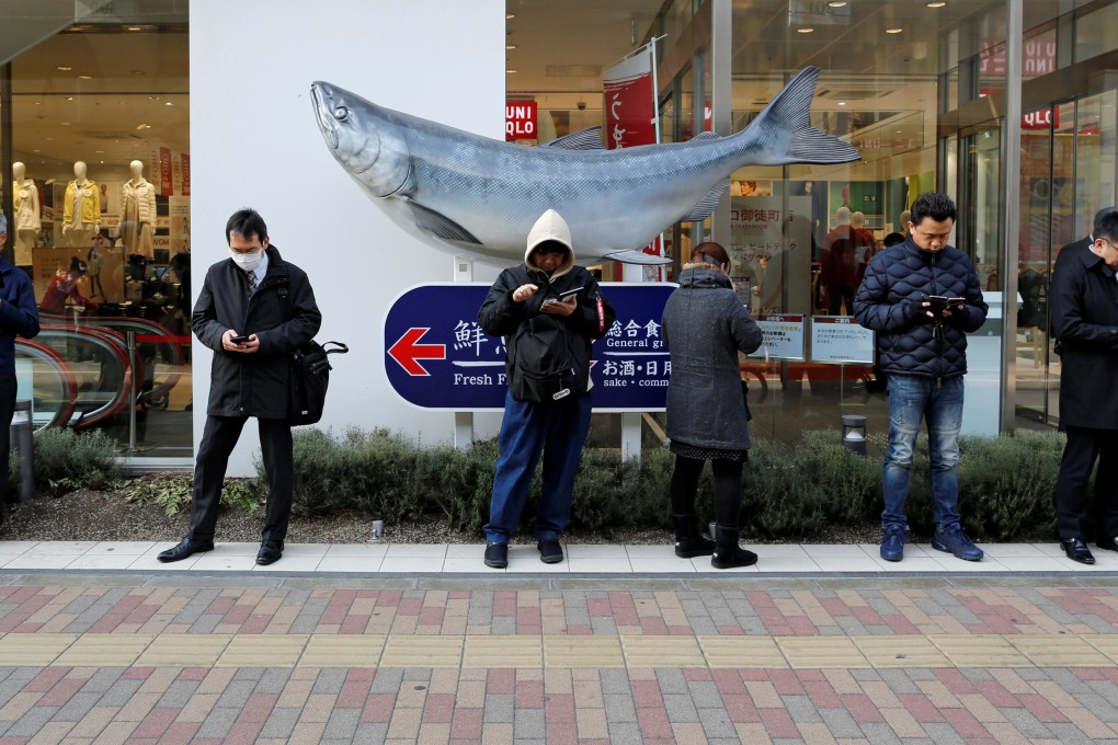 People use their smartphones on a street in Tokyo. Photo: Reuters