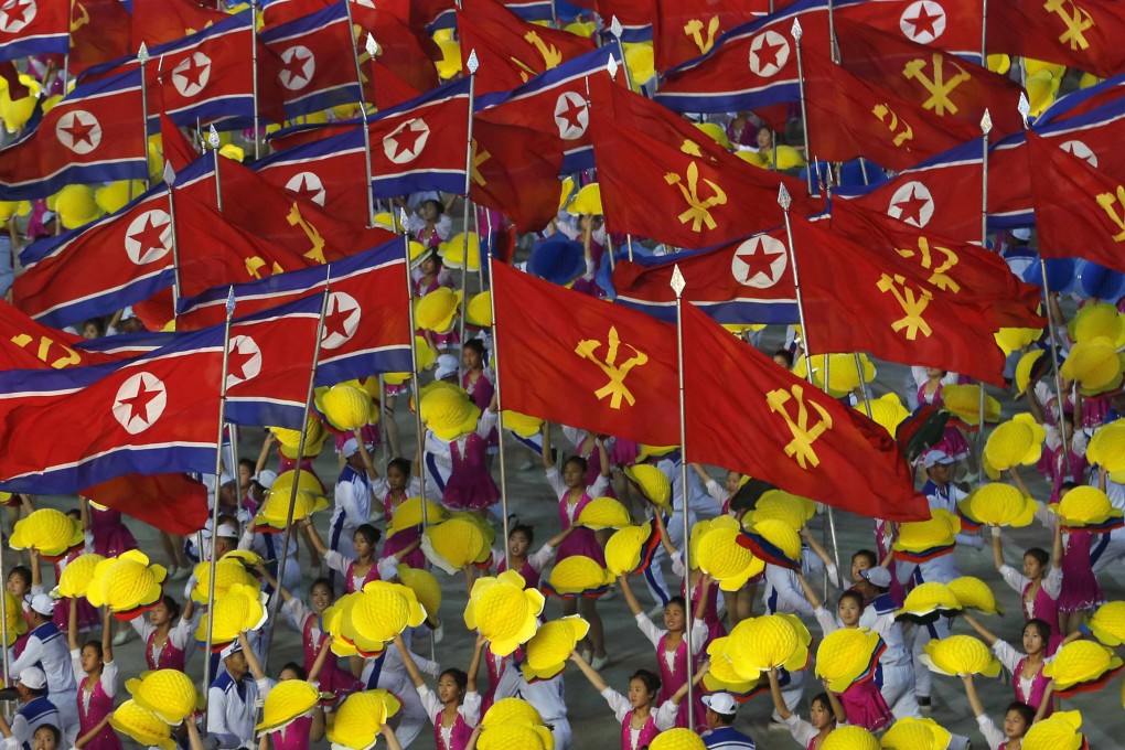 FILE - In this Oct. 25, 2018, file photo, dancers wave flags of North Korea and Korean Workers' Party as they perform during "The Glorious Country" mass games at May Day Stadium in Pyongyang, North Korea. North Korea has extended the run of the iconic mass games, which it revived last month to mark the country's 70th birthday.(AP Photo/Dita Alangkara, File)