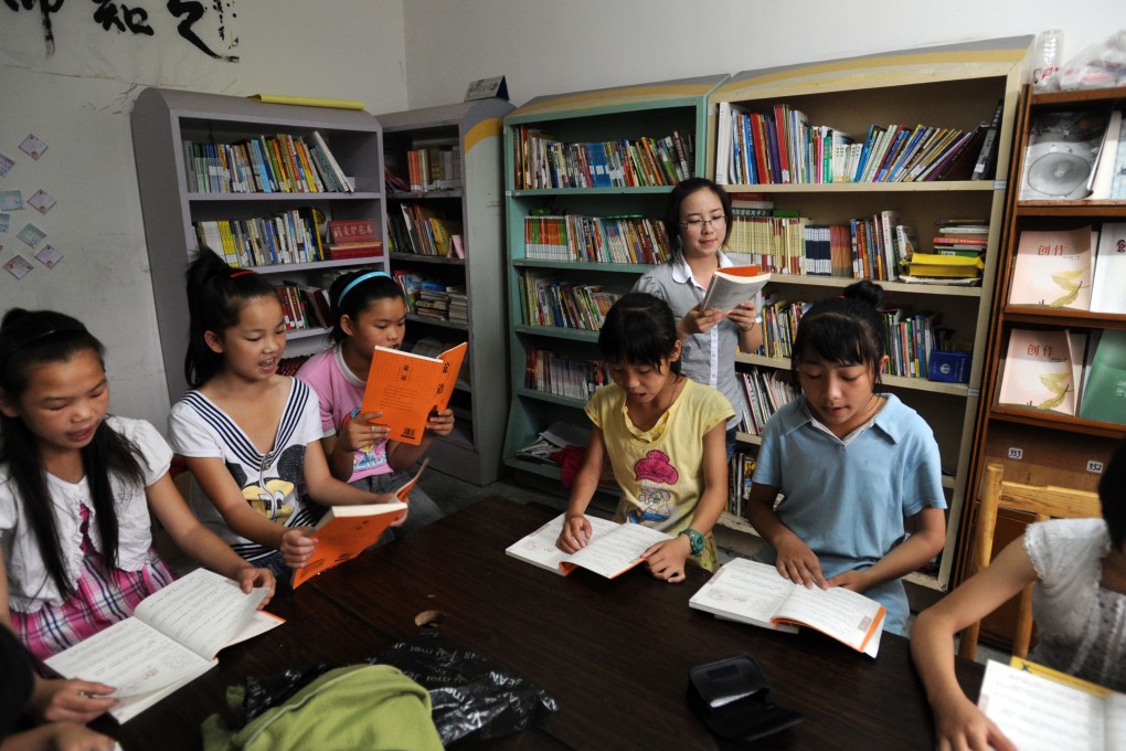A volunteer who is a student from a local university teaches children at the Farmhouse School in Longdong village, Changsha city, China. Photo: Handout
