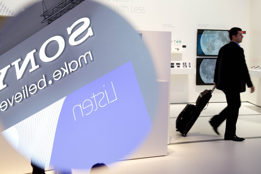 A visitor walks past a television display as the Sony logo is reflected in a mirror at a booth of the Japanese consumer electronics giant. Photo: Agence France-Presse