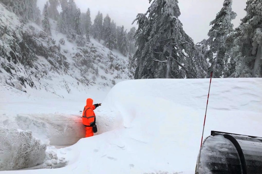 A California Department of Transportation worker standing in a snow drift on California State Route 2, the Angeles Crest Highway, in the San Gabriel Mountains above Montrose in Southern California. Photo: AP