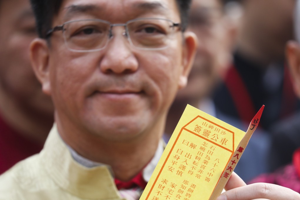 Heung Yee Kuk chairman and lawmaker Kenneth Lau holds up the “average” fortune stick he picked for Hong Kong on the second day of the Lunar New Year, at Sha Tin’s Che Kung Temple. We don’t need a fortune stick to tell us that tough times lie ahead. Photo: Dickson Lee
