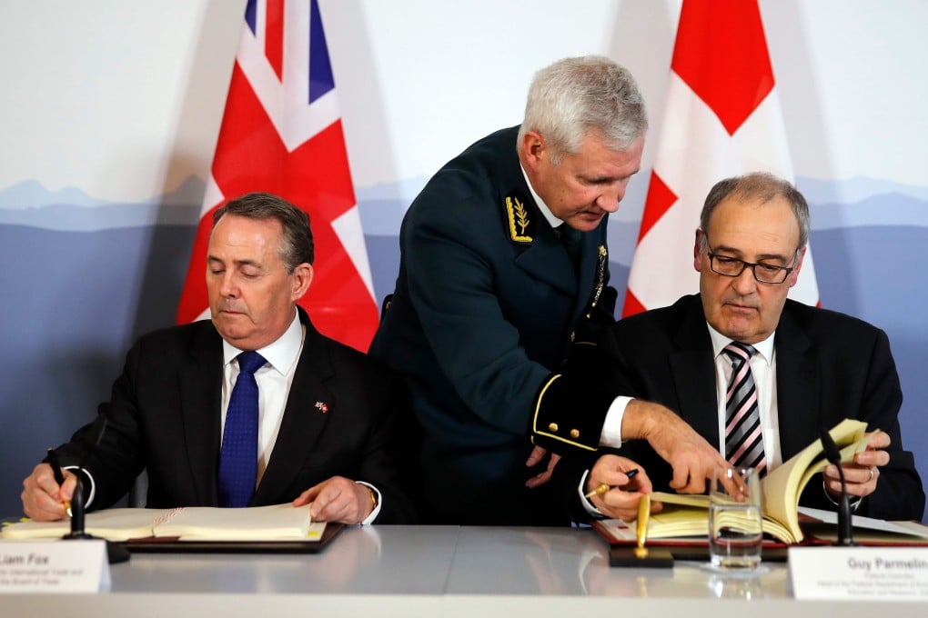 Britain’s International Trade Secretary Liam Fox (left) and Swiss Economic Minister Guy Parmelin (right) sign an agreement in Bern on February 11, 2019, to preserve trade relations between the two countries. Photo: AFP