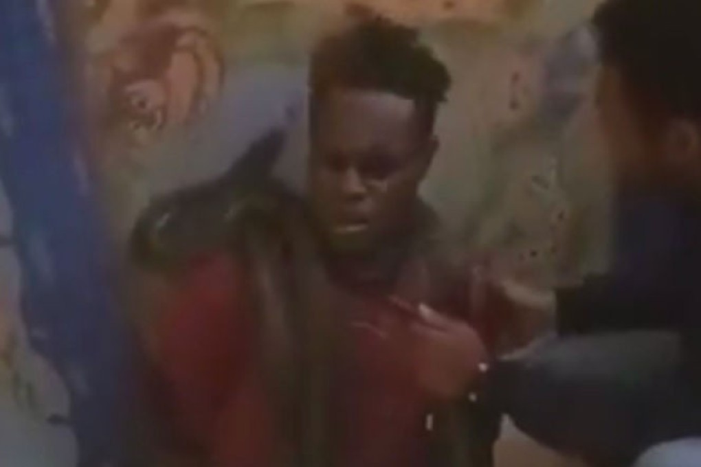 Video footage of a man appearing to be tortured by a Indonesian police officer with a snake. Photo: Screengrab from Twitter video