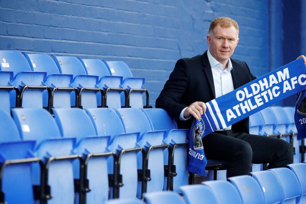 New Oldham Athletic manager Paul Scholes poses with a club scarf after the press conference. Photo: Reuters