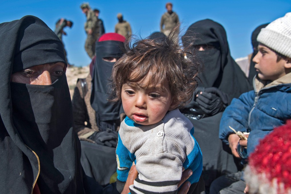 Fully veiled women and children stand in a field after they fled from the Baghouz area in the eastern Syrian province of Deir Ezzor on February 12, 2019 during an operation by the US-backed Syrian Democratic Forces (SDF) to expel hundreds of Islamic State group (IS) jihadists from the region. Photo: AFP