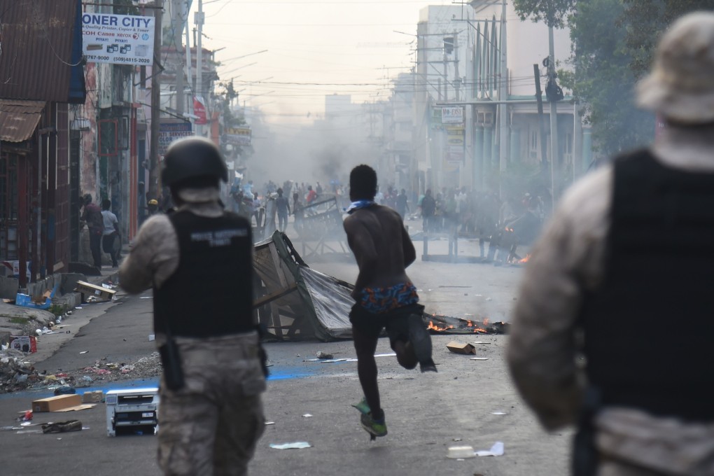 Haitian Police shoot at a man who was caught looting a shop in the centre of Haitian Capital Port-au-Prince on February 12, the sixth straight day of protests. Photo: AFP