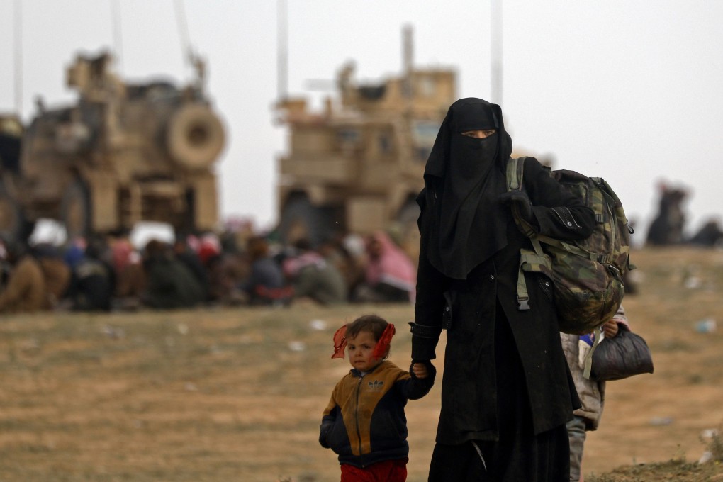 Civilians fleeing the Islamic State's group embattled holdout of Baghouz walk in a field on February 13, 2019 during an operation by the US-backed Syrian Democratic Forces (SDF) to expel the Islamic State group from the area, in the eastern Syrian province of Deir Ezzor. Photo: AFP