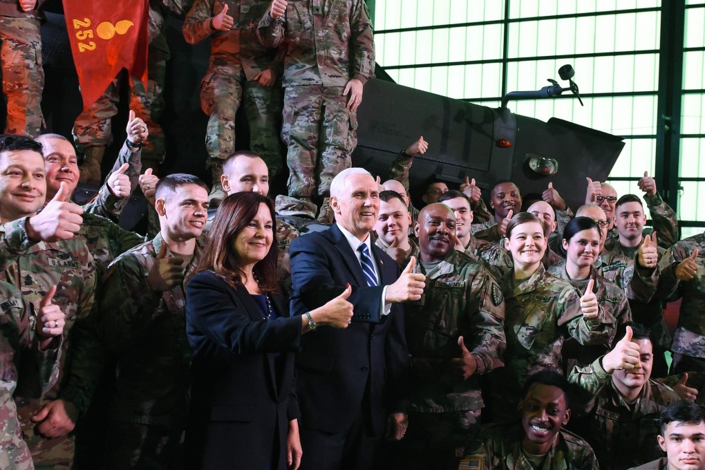 US Vice-President Mike Pence (centre, in suit and tie) and his wife Karen Pence pose with soldiers at the 1st Airlift Base in Warsaw, on February 13, 2019 during a three-day visit of the US Vice President to Poland. Photo: AFP