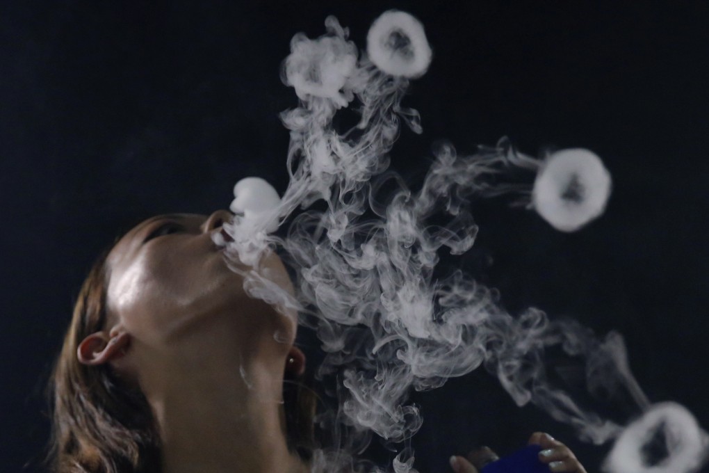 A Hong Kong smoker demonstrates electronic cigarettes. The city plans to ban the sale of e-cigarettes and other new smoking products. Photo: AP