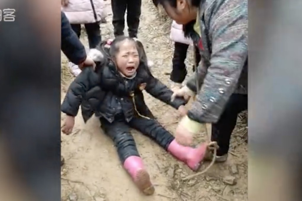 A girl cries as her parents prepare to return to their jobs in the city. Photo: Qq.com