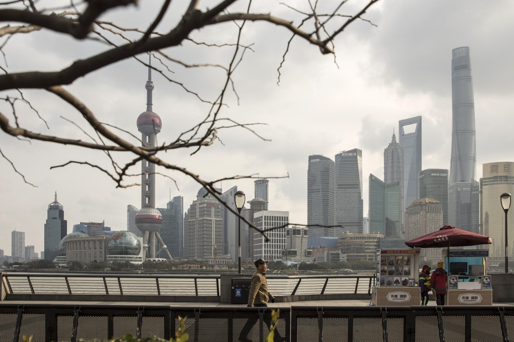 Pedestrians walk along the bund as skyscrapers of the Pudong Lujiazui Financial District stand across the Huangpu River in Shanghai on December 28, 2018. Photo: Bloomberg