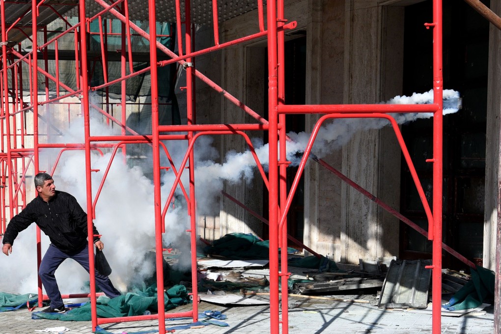 A Albanian opposition supporter throws an object at the door of the prime minister's office during a protest demanding his resignation, on February 16, 2019, in Tirana. Photo: AFP