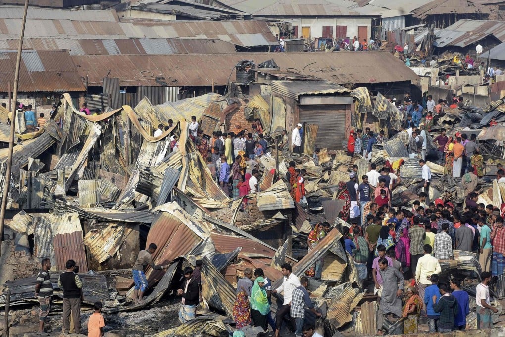 Residents walk past their destroyed houses after a fire broke out in Chittagong on February 17, 2019. Photo: AFP