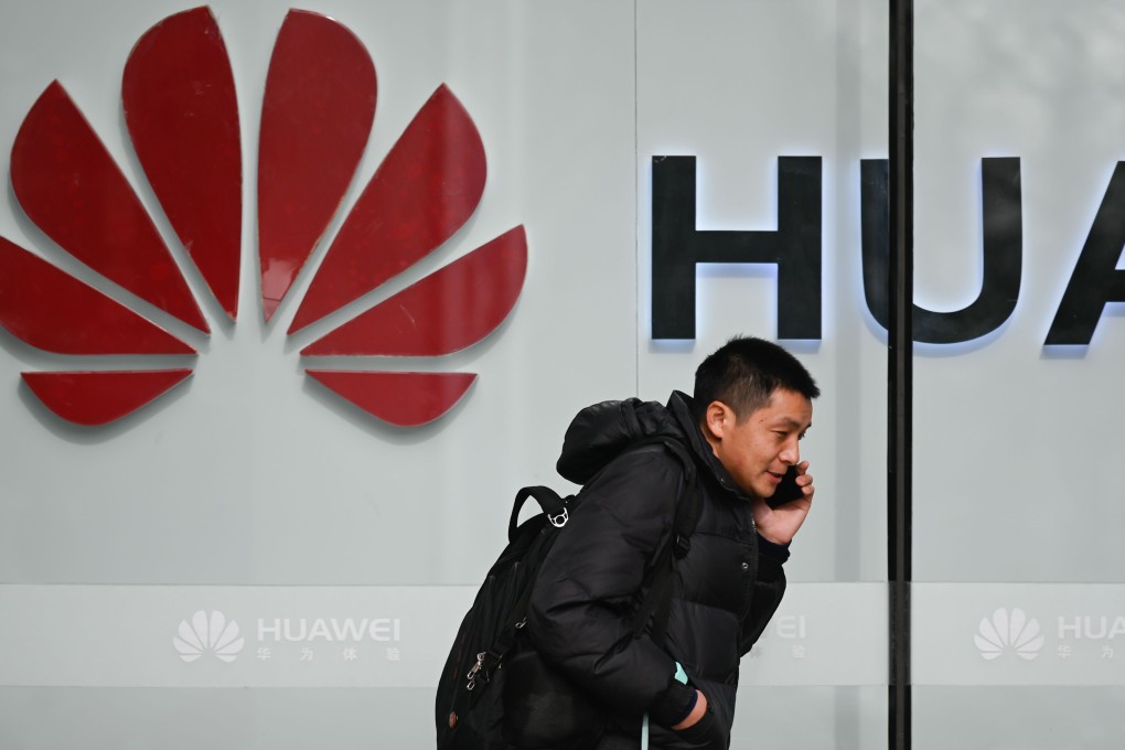 A pedestrian talks on his phone while he walks past a Huawei store in Beijing on January 30, 2019. Photo: Agence France-Presse