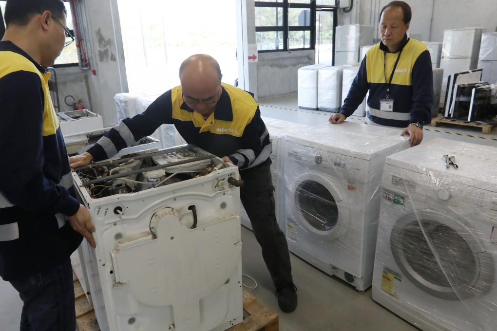 Staff at the recycling plant working on discarded washing machines. Photo: Edward Wong