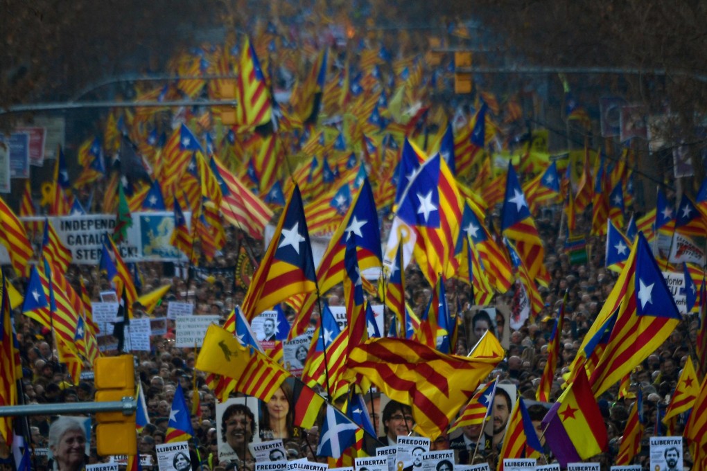 Demonstrators hold portraits of jailed Catalan separatists and wave Catalan pro-independence Estelada flags during a protest against the trial of former Catalan separatist leaders in Barcelona on February 16, 2019. Photo: AFP