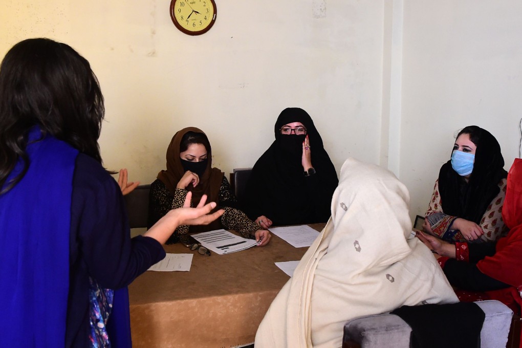 Ayeesha (left), an employee of the Pakistani NGO Aware Girls, briefs other employees on how to treat and answer calls on the hotline. Photo: AFP
