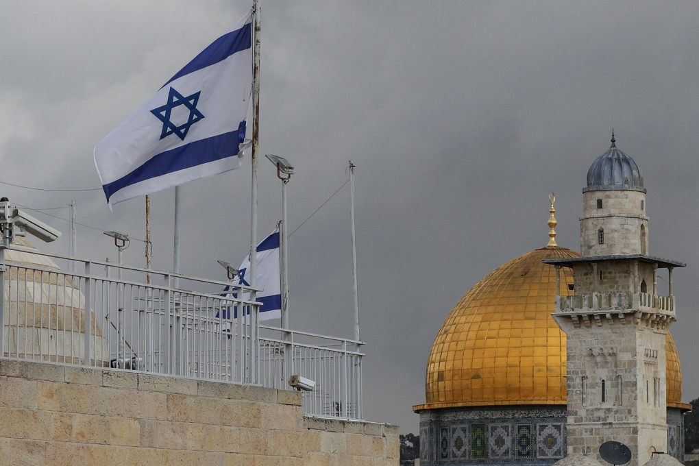 Israeli flags flutter atop a building in Jerusalem’s old city next to the Dome of the Rock mosque situated in the al-Aqsa mosque compound in Jerusalem’s old city. Photo: AFP