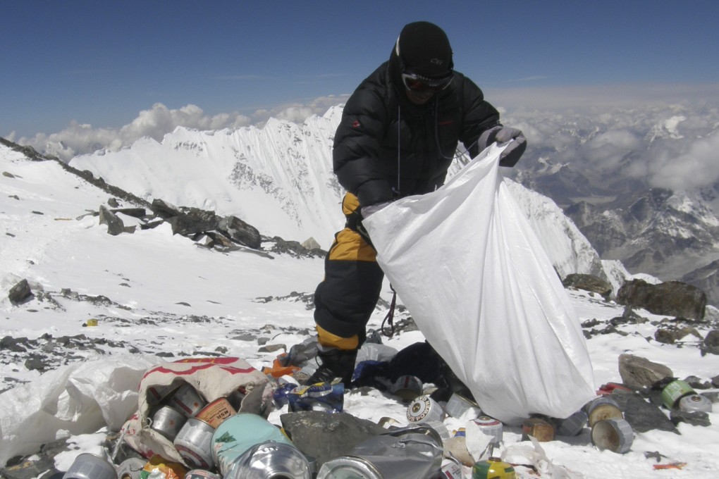 A sherpa collects rubbish left on Mount Everest in a truer reflection of the situation. Photo: AFP
