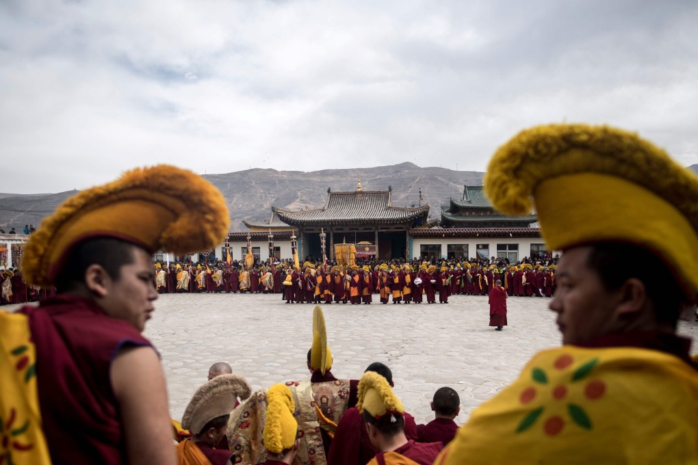 Tibetan Buddhist monks pray during a ceremony at a monastery in Qinghai. A county in the province has banned children from attending language classes taught by monks. Photo: AFP