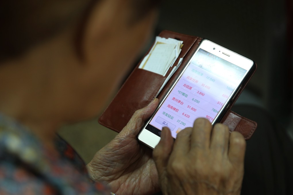 A Chinese investor uses her mobile phone to check stock prices. Photo: EPA