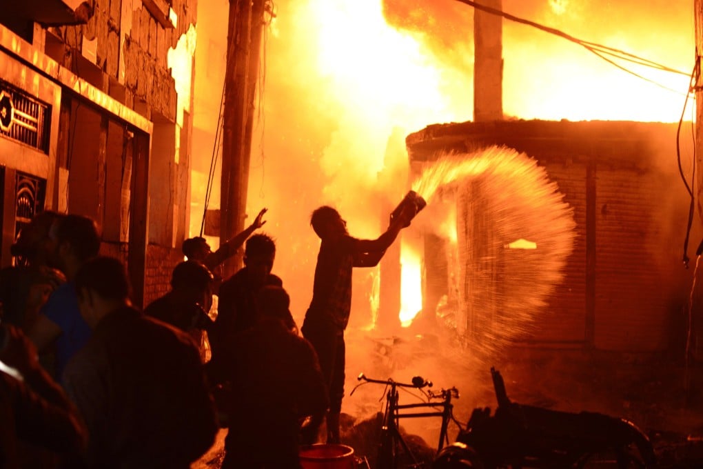 Firefighters and local people help douse a fire in Dhaka. Photo: AP