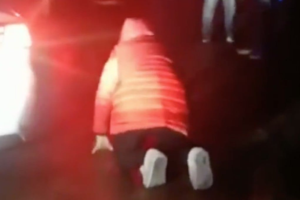 A woman kneels and pleads with motorists to get out of an emergency lane so an ambulance can take her father to hospital in Luan, Anhui province, last week. Photo: Pear Video